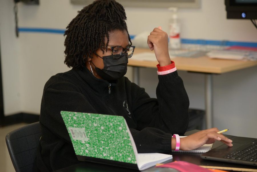A UHSSE student doing work while wearing a mask.