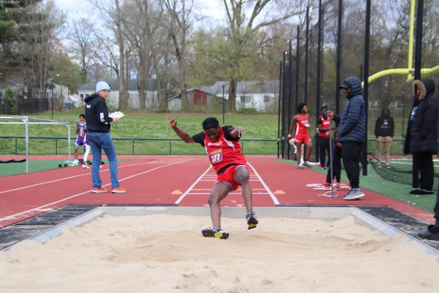 Ethan St. Ange 26 lands in the sand pit after a long jump.