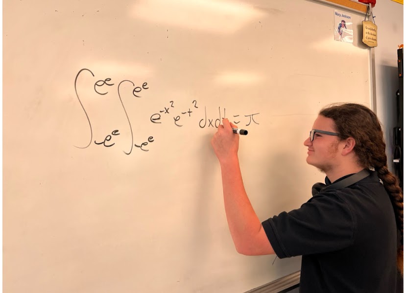 Carl Allen '27 working at the board during a math team meeting. 