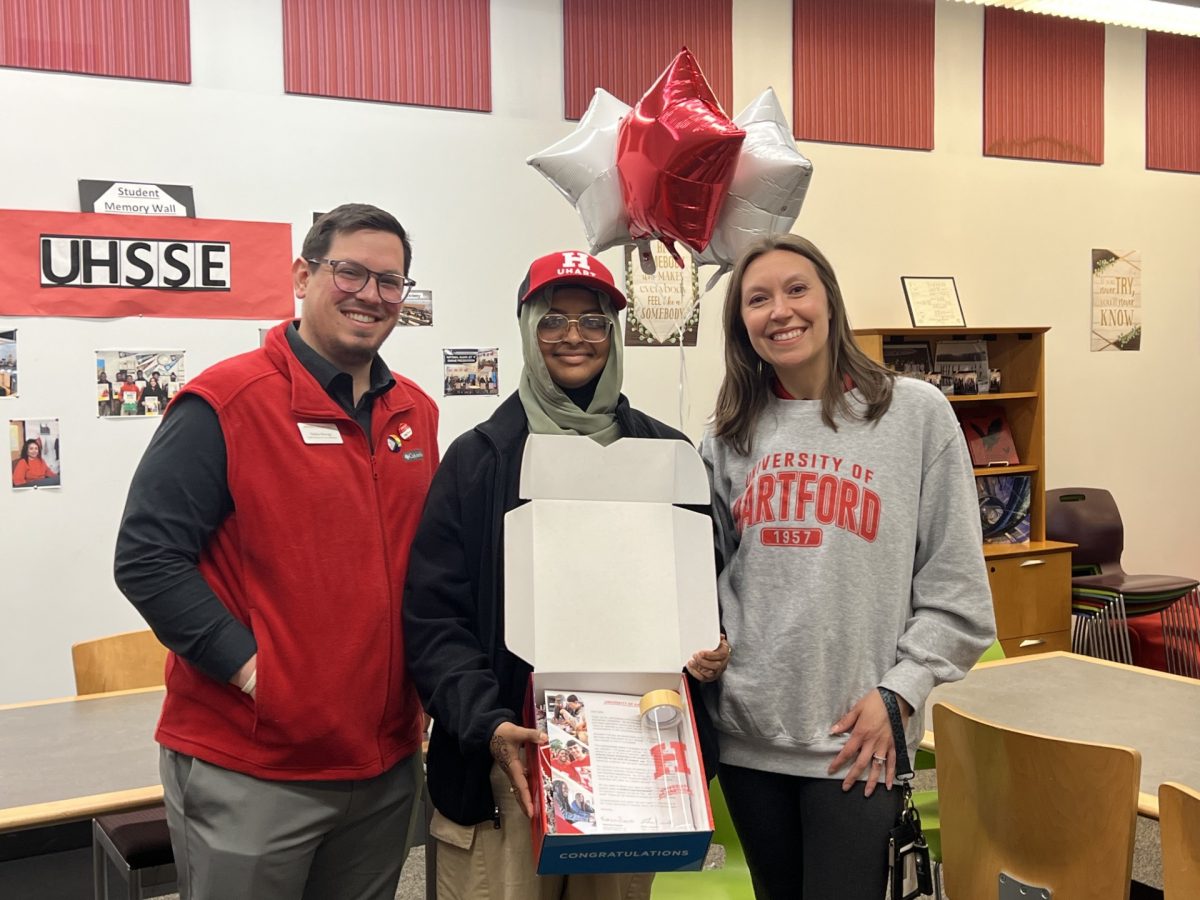 Senior Safia Ali pictured in the STEM Center with Nicole Mazzarella and senior assistant director of admissions Nathan Burrage from the University of Hartford as she receives her full-ride to UHart. 